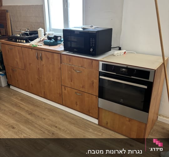 מטבח עם ארונות עץ ותנור אפייה